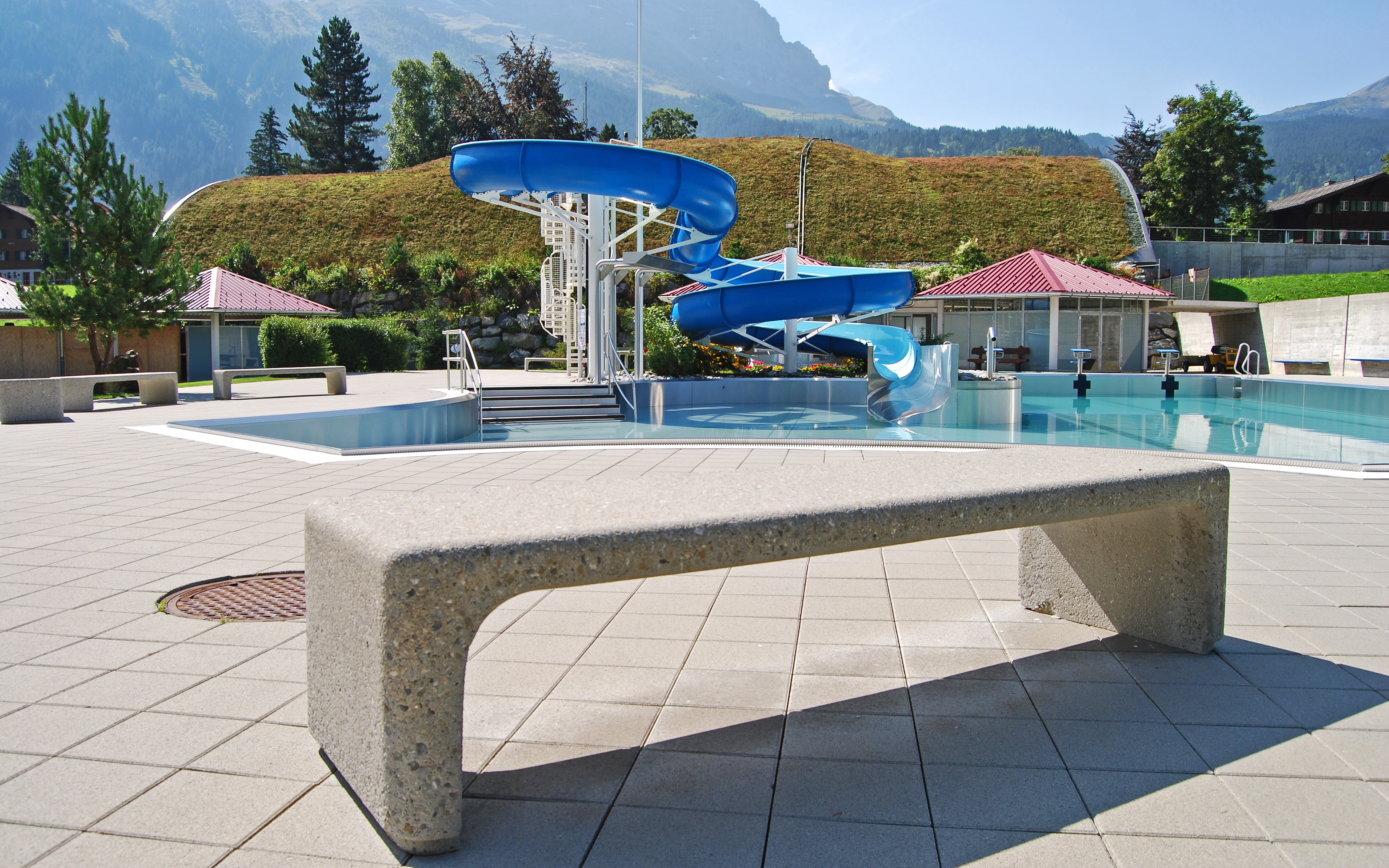 Piscine avec un bâtiment avec un toit vert