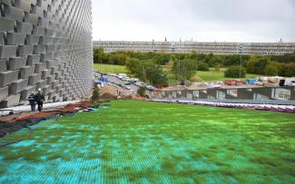 Ski slope on synthetic mats and grass growing through on a pitched roof